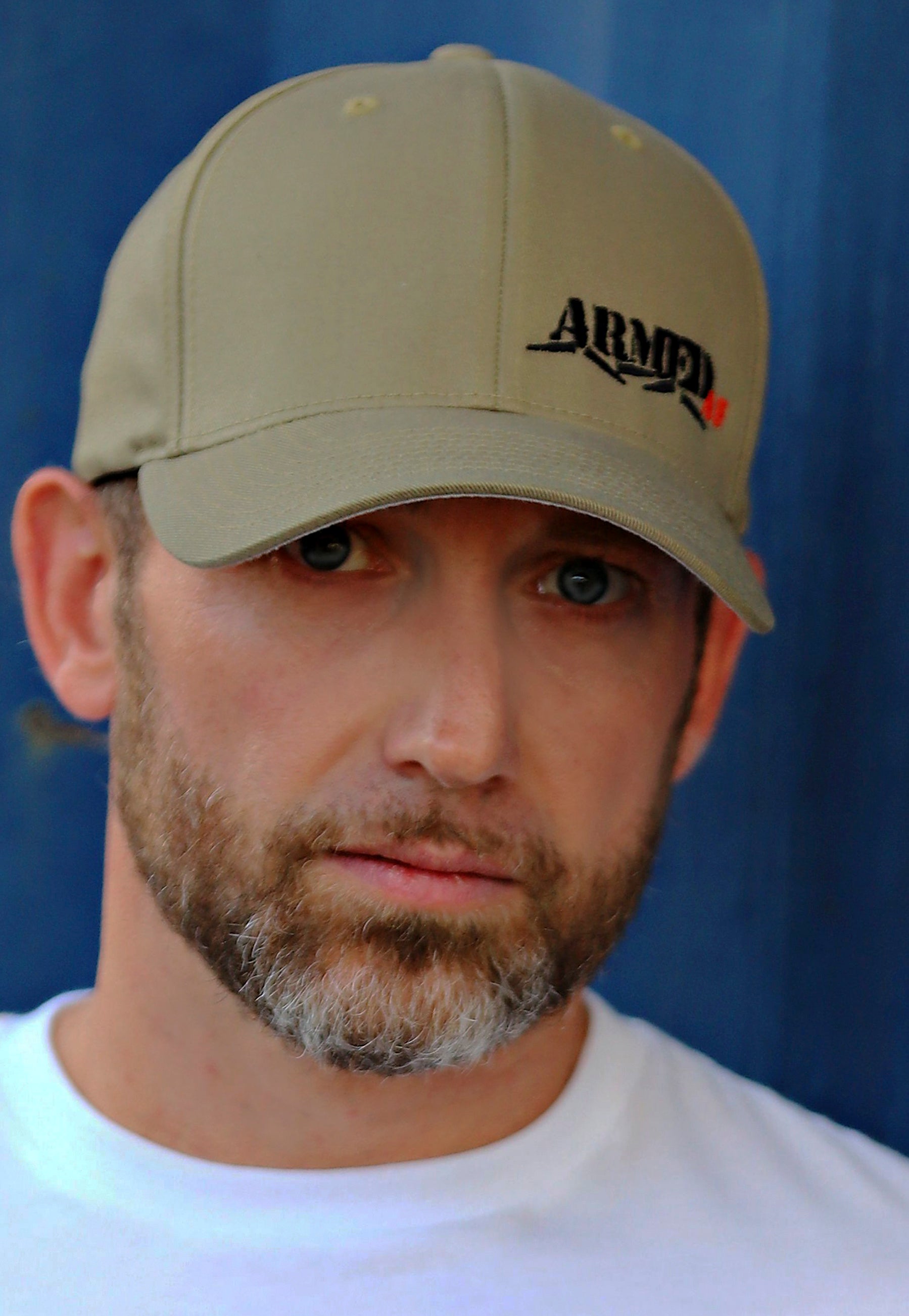 Male model wearing ArmedAF® logo hat in coyote brown